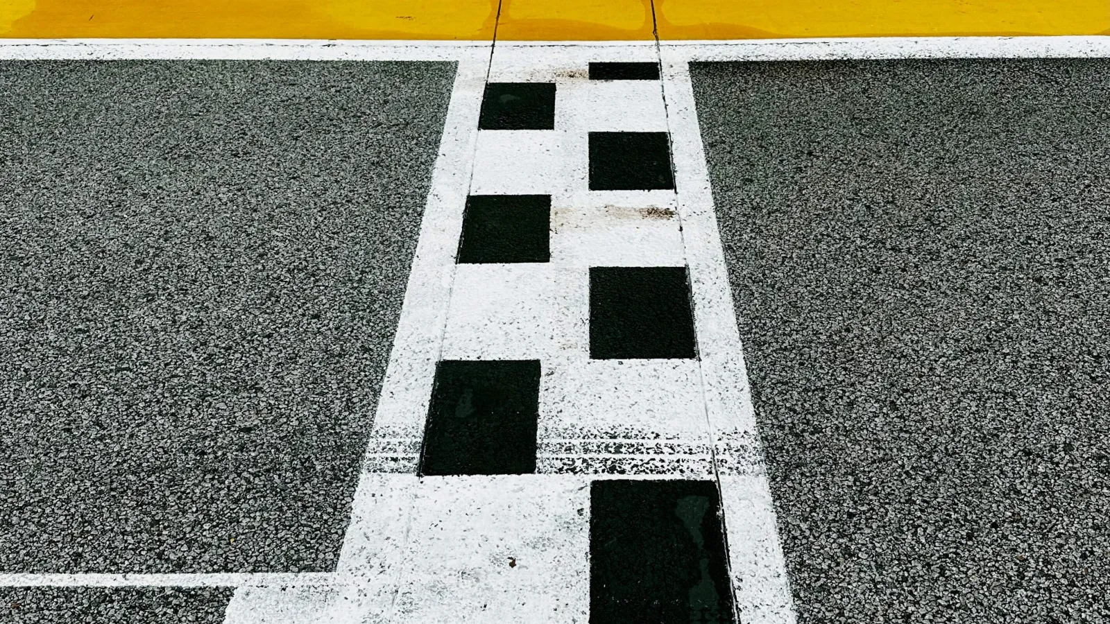 Focus on the start and finish line of the Singapore F1 track with Singapore Airlines ads on the track wall.